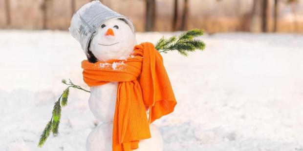 funny snowman with an orange scarf and a bucket on its head