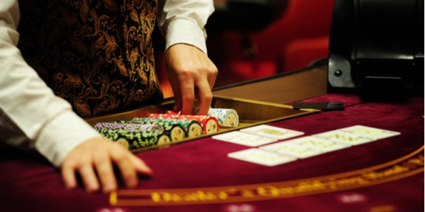 A poker dealer revealing the cards on a poker table. 