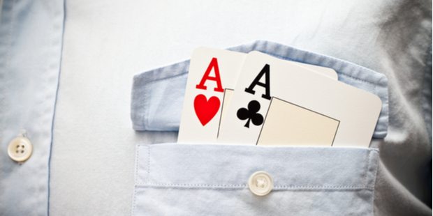 two aces tucked into the pocket of a dress shirt.