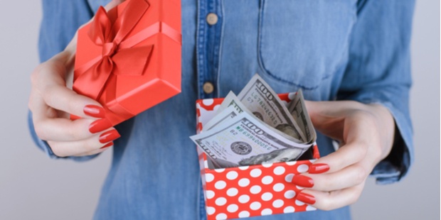 woman holding an open gift box filled with cash