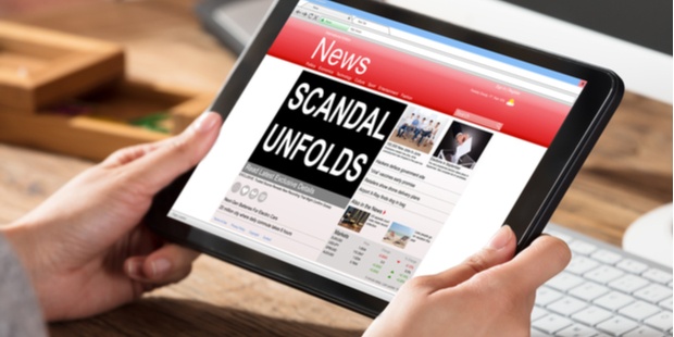 woman reading a news article on a tablet, titled scandal unfolds